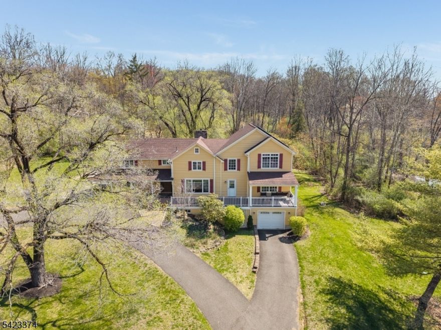 Nestled in one of High Bridge's most sought-after neighborhoods, Woodland Estates, this captivating home is rich in character and surrounded by natural beauty. Blending modern comforts with rustic charm and direct access to the outdoors, it offers a rare opportunity for a lifestyle of ease, tranquility, and adventure. The Living Room features an antique wood-beamed ceiling and a stunning stone fireplace with a wood-burning insert, flowing seamlessly into a sun-filled Dining Room highlighted by nearly floor-to-ceiling windows. A spacious yet inviting Family Room provides the perfect setting for movie nights and gatherings. The Eat-In Kitchen is equipped with stainless steel appliances and offers convenient ground-level access. For year-round enjoyment, the Three-Season Room delivers panoramic views and a cozy, heated retreat for crisp fall evenings. Upstairs, the impressive Primary Suite boasts a vaulted ceiling, a large walk-in closet, and a beautifully appointed Full Bath with dual sinks and an oversized shower. Three additional Bedrooms, a second fully renovated Full Bath, and a charming Library complete the upper level. Outside the private, level yard spans 0.61 acres and backs to wooded open space with scenic mountain biking trails, all set on a peaceful cul-de-sac. High Bridge is a community-driven town with many events including the Soapbox Derby, numerous parks and trails for the nature enthusiasts, and the High Bridge Hills Golf Club, just down the road. Welcome Home!