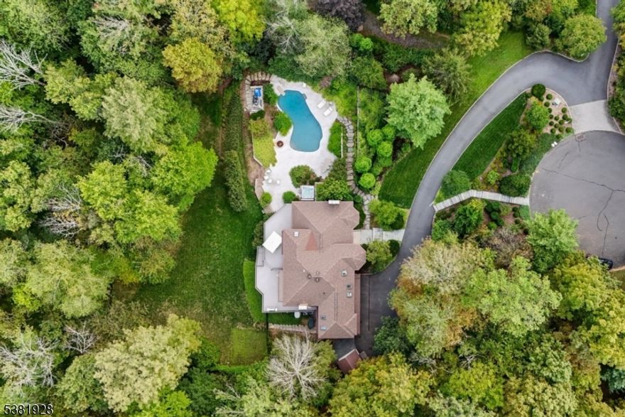 This stunning home feels like a year round vacation! Perfectly situated on a quiet cul-de-sac with easy access to town, restaurants, top-rated schools, and major highways, it offers the perfect balance of privacy and convenience. The resort style backyard is a true escape with a newer gunite pool, hot tub, travertine deck, and lush landscaping and amazing hardscaping setting the stage for your own private oasis. Inside, a dramatic two-story foyer leads to a sun filled living room with vaulted ceiling and fireplace, a formal dining room, and a renovated white eat in chef's kitchen with SubZero, 6-burner Wolf stove, and sliders to a large two-tier deck overlooking the serene property. The kitchen flows into the family room with fireplace and custom built-ins. A private office, mudroom with laundry, powder room and 2.5 car garage completes this level. Just a few steps up are three ensuite bedrooms all with walk in closets, including a magnificent primary suite with sitting room, two walk-in closets, and a new spa like bath with freestanding tub and large stall shower. The walk out lower level is designed for fun and functionality with a bedroom and ensuite bath, recreation room with fireplace, storage, and workshop. Direct pool access makes summer entertaining effortless from this lower level. Many updates kitchen, roof, painting, water heater, and more. With its elegant design, luxurious amenities, and vacation like setting, this great home is one you'll never want to leave!