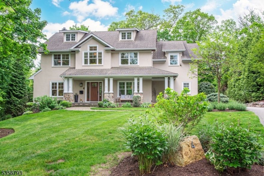 Discover this stunning 2013 custom colonial on a serene 0.50-acre lot at the end of a cul-de-sac, adjacent to Esplanade Park. This energy-efficient gem combines quality craftsmanship with modern amenities for effortless living. The home features a welcoming stone-covered front porch, leading to a spacious living room and elegant dining room with coffered ceiling. The gourmet kitchen boasts a large center island, wet bar, custom cherry cabinetry, granite countertops, and high-end appliances, opening to a sunny breakfast area and expansive Trex deck for outdoor dining. Enjoy the bright family room with a gas fireplace and walls of windows, plus the convenience of a covered side porch entrance, tiled mudroom, well-equipped laundry room, and custom pantry. The two-car garage comes with a custom storage system. The second floor offers three generous bedrooms and a hall bath with double vanity. In addition, the luxurious primary suite includes a sitting room, bedroom with gas fireplace, dual walk-in closets, and a lavish bath. The third level adds a fifth bedroom, office and full bath. The finished lower level features a gym, recreation/media room, and climate-controlled wine cellar. Extra features include a water purification system, whole house generator, and security alarm. Located in the heart of town, close to schools, lake activities, train station, library, and Hapgoods' Deli, this home invites you to embrace the Mountain Lakes lifestyle.