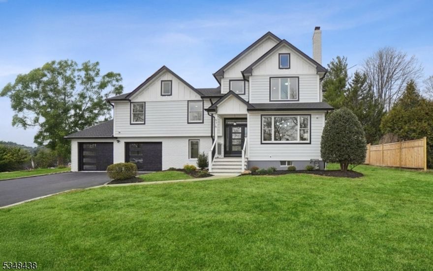 This COMPLETELY RENOVATED and newly ADD-A-LEVEL home is an absolute masterpiece, showcasing an array of CONTEMPORARY designer features and CUSTOM finishes. No detail has been overlooked in this luxurious residence! The heart of the home is the Chef's kitchen, featuring Fabuwood soft-close cabinetry, a large island with a built-in microwave, and stunning waterfall Calacatta ultra quartz counters. Bertazzoni S/S appliances, a beautiful tile backsplash and sleek finishes make this kitchen an entertainer's dream. The kitchen flows seamlessly into the family room, which opens to a Trex deck and patio. The living room boasts a striking granite-surround fireplace, and the dining room offers a wet bar with wine fridge  perfect for hosting. Upstairs, the primary suite is a private retreat with CUSTOM walk-in closets, private balcony, and a luxurious spa-like bath. Four additional generously-sized bedrooms provide ample space. On the ground floor, a guest BR w/an ensuite bathroom offers flexibility for use as a home office. The lower level features a rec. room for additional entertainment space. With high ceilings, stunning millwork, Pella and Andersen windows, HardiePlank siding, and a Timberline roof, this home exudes quality. Additional features include premium bathrooms w/custom shower doors, 2-zone HVAC, tankless H/W/H, oak hardwood floors, Masonite solid wood doors, a newly paved driveway and 6' privacy fence. Conveniently located near top-rated schools, parks, shops & NYC train!