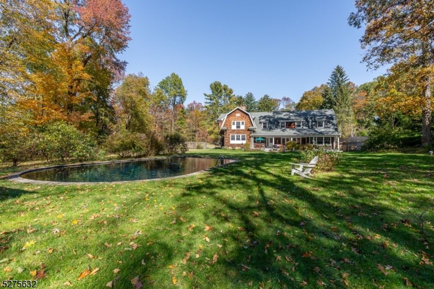 A classic shingle style estate is surrounded by two acres of open, level lawns on the Bernardsville Mountain. Its impressive floor plan offers five bedrooms, four full baths and a powder room arranged on three finished levels. Originally built in 1890, this inviting residence has been carefully upgraded through the years, most recently in 2002. Mature specimen trees, lush gardens, stone walls, bluestone terraces and a refreshing pool enhance the beautiful setting. Inside, formal living and dining rooms, a chef's center island kitchen, first floor guest suite and spacious primary suite offer an ideal balance of public and private spaces. The gracious floor plan includes white oak wood and cork floors, high ceilings, expansive windows, generous room sizes, French doors, two wet bars, two wood-burning fireplaces, built-ins and recessed lighting. Approached by circular drive with parking court, the timeless architecture clad in cedar shingles features an attached greenhouse.