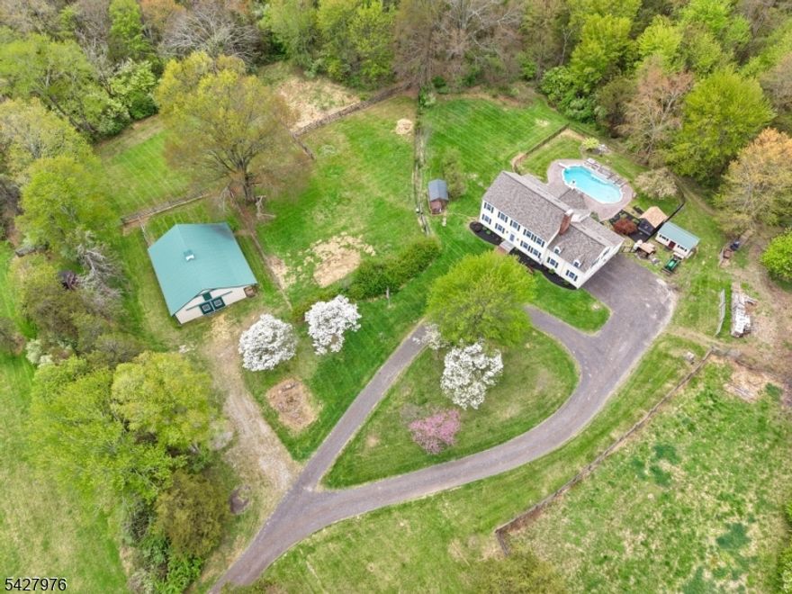 Set on nearly 15 acres of peaceful, private land, this exceptional property offers a rare blend of refined living and connection to nature. A long approach reveals a beautiful balance of open fields and wooded surroundings, creating a setting that feels both expansive and serene. The home features 4 bedrooms and 3.1 baths, including a full bath on the main level with easy backyard access, ideal for poolside living. Hardwood floors and light-filled interiors flow throughout, enhanced by skylights, expansive windows, and thoughtfully placed sliding doors. The updated kitchen opens seamlessly to a stunning family room with a vaulted, beamed ceiling & a floor-to-ceiling stone fireplace. Nearly every room captures tranquil views of the surrounding landscape. The first level also includes a formal dining room, sitting room, office, powder room, & access to the attached three-car garage. Upstairs offers a laundry room & a spacious bonus room with flexible use. Outdoors, enjoy a in-ground pool with waterfall, a 7-stall barn with tack room & loft, multiple pastures, & additional outbuildings. Minutes to Lambertville, New Hope, Stockton, Frenchtown, Hopewell Borough, & Princeton. Nearby preserved land and the Sourland Mountains offer endless outdoor enjoyment. Updates include a kitchen and dining addition (2012), roof and skylights (2021), front steps (2023), interior painting (2024"2025), and a Generac whole-house generator (2025). BEST & FINAL OFFERS DUE THURSDAY MAY 7th at NOON