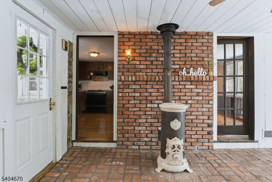 Warm, welcoming, and full of character, this Lake Mohawk ranch on a large 128 x 345 lot feels like home from the moment you step inside. Rich wood details throughout create a cozy, timeless atmosphere, complete with a lovely fireplace that adds charm to the living space. The kitchen provides ample cabinetry and an easy, functional layout for everyday living, while hardwood floors lead you into the dining room filled with natural light. The den features a second fireplace, access to the two-car garage, and a sliding door that opens to a large rear deck overlooking expansive green space perfect for entertaining, relaxing, or enjoying the outdoors. Central air adds year-round comfort. The lower level includes an additional bedroom with a full bath, a large recreation room, utility space, and walkout access to the backyard. Located in the desirable Alpine section of Lake Mohawk, this home blends character, space, and lifestyle while offering access to the scenic lake, beaches, clubhouse, and a vibrant community atmosphere.