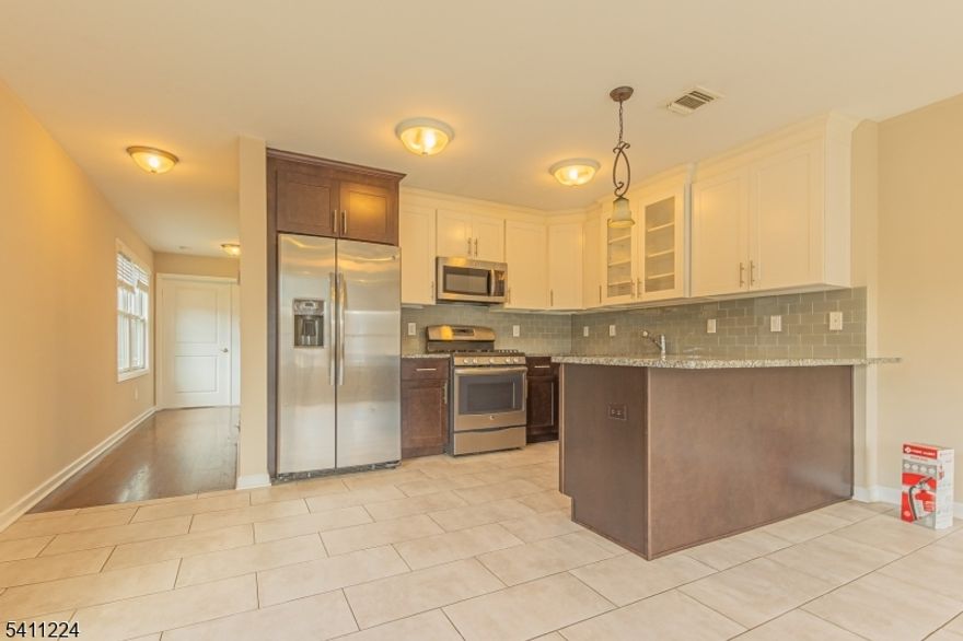 Welcome to Platinum Townhomes! This newly constructed 2,250SF 5-room townhouse offers 3 floors of flexible living space, plus a private 1-cargarage and driveway. Ground floor has private entrance from front door and from garage, a half bath, and a den/playroom with sliding glass doors to private patio.Main floor offers a modern kitchen with stainless steel appliances (including dishwasher and large 24.8 cu-ft GE refrigerator) and an open layout with a largedining area, as well as a separate formal living room or potential bedroom/office, and an additional half bathroom. Top floor offers laundry washer and dryer,bedroom, hallway full bathroom, as well as master bedroom and master bath with 2 sinks. Total number of bathrooms throughout the townhouse include 2 fullbaths and 2 half baths. Interior includes porcelain tiles in both the kitchen and living room with hardwood flooring throughout the rest of the house. Thetownhouse has high efficiency forced air, gas heating system & central air conditioning systems as well as burglar alarm system. Tons of closet and storagespace throughout the unit. Close to NYC- Lincoln Tunnel and George Washington Bridge. Transportation nearby. Owner pay for taxes and parking