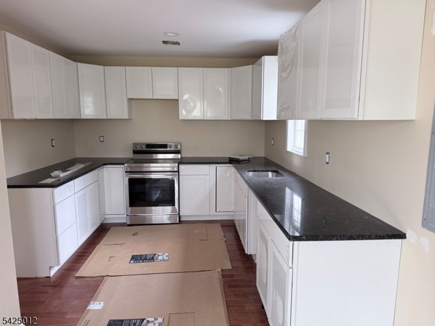 This home has been mostly completed with new kitchen, bath, windows, doors, sheetrock, insulation and hardwood floors    requires some finishing touches, a well and connect to grinder for public sewer.    The home needs a cash or renovation loan customer.    Great opportunity to build instant equity.   Plumbing and electrical is done and passed the rough.   Basement plumbing is done but needs more work.    1st floor is mostly complete