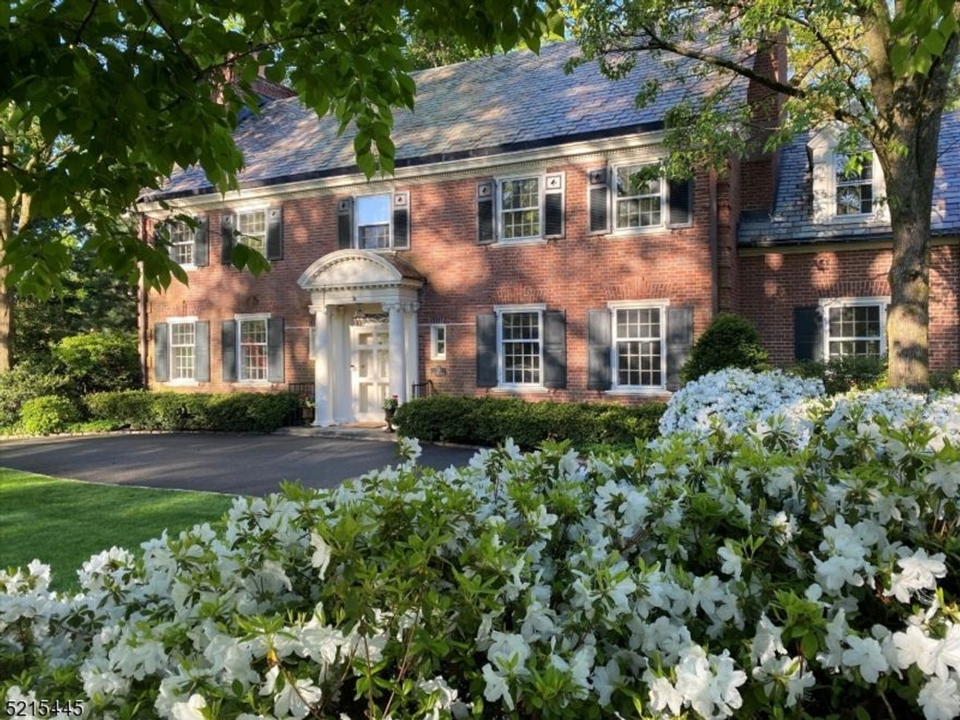 This classic Georgian-style property offers timeless elegance and beauty. Designed by renowned architect John Russell Pope, this stunning home is situated on a quiet street and boasts 2/3 of an acre of beautiful landscaping and mature plantings. Step inside and you'll be in awe of the magnificent architectural detail and modern updates that have been carefully curated throughout. The new Chef's Kitchen is highlighted by a stunning 10' double mitered quartz island, custom inset cabinetry, an English farmhouse sink and extends to include a separate Breakfast area and combination Butlers Pantry and Wet Bar. The main floor also includes a beautiful Living Room with a wood-burning fireplace, an inviting formal Dining Room with a gas fireplace, and a charming Sun Room with a curved exterior wall and a triple set of French doors opening to the magnificent - and fully fenced - yard.  Outside a bluestone patio, hand-crafted wood-burning fireplace, Walpole pergola, and hot tub are all illuminated by moon lights. Upstairs is a primary suite with a newly renovated bath, plus four additional bedrooms (one currently used as an office) and three additional baths. Conveniently located in one of the most sought-after locations in town within a half mile of the Midtown Direct train station and all of the top-rated GR schools, this is truly the perfect forever home to love and enjoy.