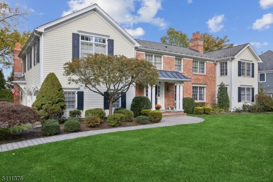 THIS IS THE ONE! Behind the historic stone wall on THE MADISON HILL, sits this stunning renovated center hall Colonial that has been meticulously updated and maintained, blending timeless craftsmanship, privacy, and modern sophistication just minutes from town, direct NYC train, and top-rated schools. Set on .44 acres, the home features hardwood floors, custom millwork, and oversized windows that fill every room with light. The formal living and dining rooms each showcase gorgeous floors and fireplaces. The spectacular kitchen w white custom cabinetry, center island, coffee bar, and desk area flows seamlessly into a vaulted Great Room w custom built-ins, spectacular windows and beautiful fireplace. A private office, cozy den and first-floor mudroom add convenience. Upstairs, five bedrooms and four baths include a luxurious primary suite with two oversized walk-in closets, a window seat, and spa-like bath. Second-floor laundry adds effortless daily convenience.The finished lower level is a dream with gym space, lg rec room, and media rm for gaming and movie nights. Large windows and full bath offer potential for an additional bedroom. Step outside to the covered back porch overlooking the private yard, patios and lovely gardens. Oversized two-car garage and gas generator completes this exceptional home. Don't miss this rare opportunity to live in this sought-after neighborhood near Triangle Park, just minutes from downtown Madison, voted the #1 town to live in NJ (NJ Monthly).