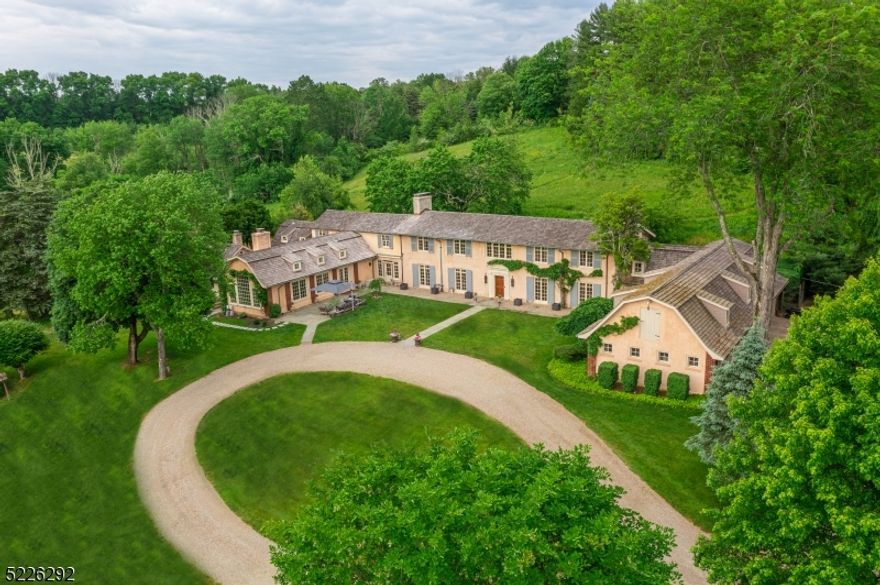 Harmony Hollow, a classic French-style estate reminiscent of Provence. Situated on 10 rolling acres with picturesque pond (8.6 farm assessed), this one-of-a-kind residence was lovingly remodeled & renovated in 2021. The estate features a guest cottage with great room with fireplace, kitchenette, bedroom, full bath, a "rocking chair" porch and a basement workshop which is heated and cooled.  The Entry Foyer, reconfigured, showcases the French limestone floor and handsome archways. Two sets of French doors lead outdoors the generous-sized living room w/FP. Of special note is the Champage/Dining Room with upholstered walls & fireplace.  A reception room just off of the entry foyer, has a powder room tucked behind an "invisible door". The 2021 Kitchen showcases custom cabinetry, Miele appliances, a LaCornue French stove, Shaws of England farm sink,  Allia of France prep sink, soapstone counter tops and a 4" thick Quartzite marble center island top.  Of special note is the "moody snack pantry". The wine-room area, informal dining area & Great Room with exposed beams, invite relaxation and fireside gatherings. Upstairs is the luxurious primary suite with a fireplace and tray ceiling featured in the bedroom, a spa-like bathroom, inviting custom dressing room, study and another full bath.  Four additional bedrooms and two bathrooms complete this level.  A 3-stall stable is attached. Pony barn.  Handsome terraces & secret garden invite outdoor living. Golf, fine dining nearby.