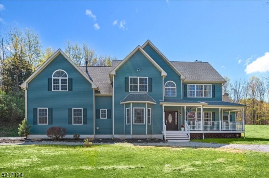 Impressive Colonial, Sprawling Property, Peaceful Bucolic Setting! This turn-key Colonial sits on 2.73 private acres in Wantage where you can enjoy airy, sun-drenched living spaces with contemporary finishes while surrounded by country tranquility. A long driveway leads you to a welcoming wraparound porch where you can relax and admire the tree-lined property. The main floor boasts gleaming hardwood floors and recessed lighting throughout, starting with an elegant 2-story foyer with retractable chandelier leading to the living room with vaulted ceiling and family room both with fireplaces. There's open flow into a gorgeous chef's kitchen with custom tile backsplash, center island with wine fridge, SS appliances including dual wall ovens and a 6-burner Viking stove with pot filler, and an adjacent breakfast area with sliding doors out to the deck and huge backyard beyond for effortless warm-weather entertaining. A formal dining room with chair rail detail can easily host everyone for dinner, half bath, laundry room, and the garage entrance complete this level. Four generously sized bedrooms can be found upstairs, including an oversized primary with tons of sunlight, dual-sided fireplace, and an adjoining spa-like bath with double vanity, walk-in shower and luxurious jetted tub. A full hall bath has an extra-wide storage vanity and tub/shower combo. The lower level houses the utilities, another access to the 3-car garage, plus abundant space ready to finish however you desire.