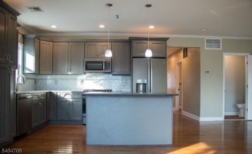 First-floor two-bedroom, two-bath apartment in a newly built two-family home. Features include an open-concept layout, hardwood floors throughout, center-island kitchen with stainless steel appliances including dishwasher, dedicated laundry room with washer and dryer in unit, and central air conditioning. Off-street parking available. Conveniently located near the Garden State Parkway, Hackensack Meridian Health, Route 3, and NYC transportation.