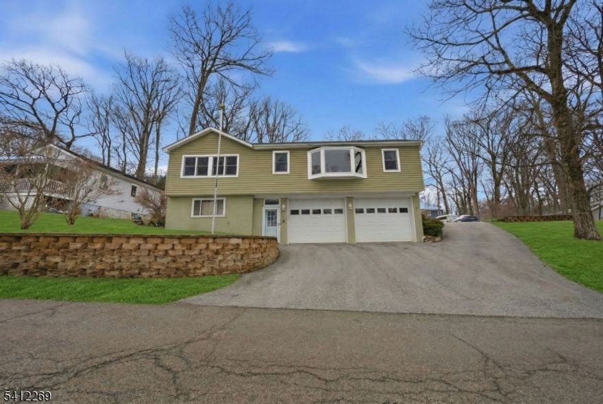 Experience this MASSIVE Raised Ranch home highlighted by a HUGE Oversized Heated Garage and 8+ Car Driveway perfect for any Motorhead, Craftsman or Hobbyist  located within minutes of highly-sought after Lake Hopatcong, New Jersey's Largest Lake & only 1 hour from NYC! This sprawling 3 Bedroom, 2.5 Bathroom home blends ample living space, large Bedrooms & Modern updates. Enjoy a spacious Living Room with Bay Window showered with natural light, gorgeous Hardwood Floors, an updated Eat-In Kitchen with High Ceilings, a Skylight & Breakfast Bar, and a Formal Dining Room. The Backyard offers TONS of hang out space, a private Deck, a Storage Shed & BONUS Additional Driveway parking making this home an Entertainers Dream! $65,000 of recent upgrades include 2 newly renovated bathrooms (2023), new furnace convertible to gas (2021), a MiniSplit AC system (2024), and a top of the line whole house water filtration system and water softener (2022). Commuters hub with easy access to major highways Rt 80, Rt 46 & Rt 10. Lake Hopatcong offers unlimited amenities including boating, fishing, swimming, beaches, waterfront dining, hiking, nearby a Ski Resort, top-rated Golf Courses and much more!
