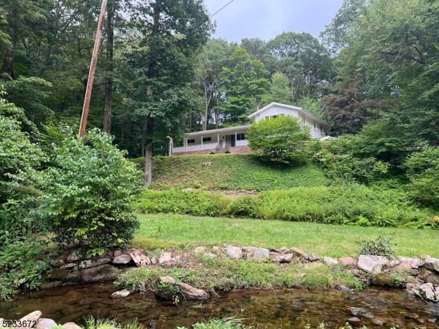 Amazing opportunity to own your very own unique turnkey split level home located in Mt. Olive, specifically in the Flanders community. This charming home is situated on over two acres of land surrounded by nature. The long driveway provides you privacy from the street.  Wake up every morning to sip your coffee while enjoying the private pond and stream on your porch. Large lot with patio, great for entertaining.  New water proof premium vinyl wood flooring in some rooms. An abundance of storage throughout so you won't have to worry about space. Central a/c and town certified 4 bedroom septic tank both installed in 2020. Enter through your porch doors into your oversized living room with exposed ceiling rafters. Primary bedroom with en-suite, bedroom, office with built-in cabinetry, and full bath complete this level. Dining room and kitchen boasts heated floors with easy access to the patio leading to fully fenced yard perfect for your pet. Top level has two additional bedrooms and a full bath. Get ready all you have to do is move in and unpack!