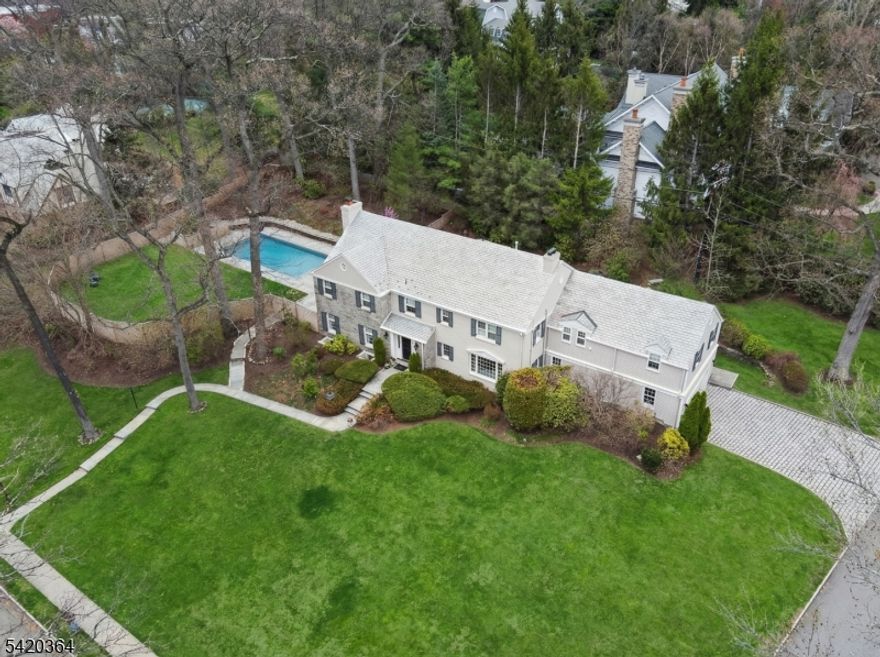 A HOME WHERE YOUR STORY THRIVES! Set on an idyllic street adjacent to Yantacaw Brook Park, this beautifully renovated gem offers a rare blend of elegance, comfort & effortless indoor-outdoor living. Stunning, fully reimagined kitchen - open, inviting, & designed for everyday life & entertaining. White marble countertops & a center island that will be the center of everything from pancakes to homework!  Adjacent family room w/gas fireplace offers a seamless flow of life & light. Inviting dining room with views of patio & gardens. Fabulous living room with windows on 3 sides, built-ins, gas fireplace & french doors to patio & pool. Stately curved staircase up to Primary Ensuite with dressing room & full bath, 4 additional bedrooms, bonus room, 2 full baths & laundry room. Fully renovated lower level is a true standout - bright & thoughtfully finished with raised flooring, wool carpeting, built-in sound, climate control, & multiple windows - a stellar space for play, fitness & gathering year-round. Outside, the vibe is private retreat. A saltwater pool with gorgeous bluestone surround & retractable cover anchors a section of the backyard with plenty of fully-fenced play space beyond.  Lush grounds, fish pond & waterfal. Belgian block driveway and slate roof add timeless appeal.  New multi-zone HVAC. Extensive updates throughout.  Space, style, and ease - just moments from parks, schools, and NYC access. More details in photo captions.