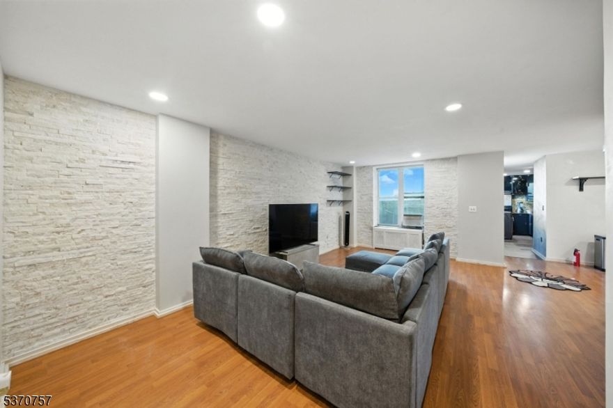 Step into sophisticated city living at Gothic Tower, a pre-war gem walking distance to the Journal Square PATH Station. This expansive 1-bedroom, 1-bath residence offers nearly 1,000 sq ft of modern elegance wrapped in timeless charm.Inside, you'll find beautiful flooring, stunning Venetian plaster marble walls, and natural stone walls that add texture and warmth. A smart voice and phone-enabled LED recessed lighting system lets you set the mood throughout the space. The fully renovated kitchen features translucent acrylic cabinet doors, LED-lit interiors, floating shelves, and new appliances perfect for stylish everyday living.The updated bathroom showcases gold accents throughout. Redwood polyurethane-finished doors, mirrored living room closet, and gold outlets add rich design details throughout.In Gothic Tower, enjoy a 24-hour doorman, fitness center, courtyard, and laundry room plus unbeatable access to St. Peter's University, local cafes, parks, and NYC via PATH.