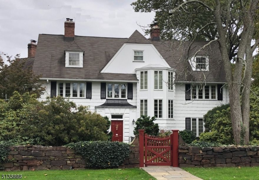 Historic center hall Colonial situated on approximately 1.5 acres in Upper Montclair. Features abound: high ceilings, cove molding, 5 fpls, bay and picture windows, many built-ins, chair rail and screen porch off LR & DR overlooking terraced grounds and pool. Charming library with fpl& original wood flrs. Updated EIK with custom wood , cabinets, granite counters, tile flrs, open area with breakfast nook, wet bar & desk plus large laundry room and 2 powder rooms. Primary suite has bedroom (fpl) ,dressing room, den (fpl) and bath. Third floor with sunny BR with bath and great playroom or bedroom plus two storage room. There is an elevator for all three floors. There are 50 new windows and steam furnace(2011). There is a lawn sprinkler system for plantings in the front.   This circa 1900 home is full of character & history and is ideally located in a quiet residential neighborhood convenient to uptown dining & shopping, and NYC bus & train.