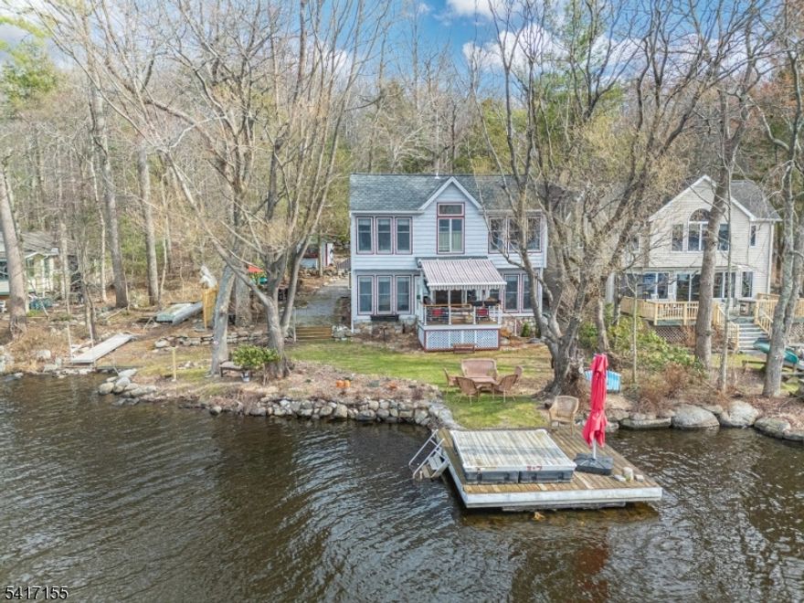 Welcome to this exceptional lakefront retreat on the east shore of private, spring-fed Lake Owassa, known for its clear waters, fishing, and motor-boat friendly lifestyle. This well-maintained home offers 3 bedrooms, and 2 full baths, plus a detached cottage with electric and heat, ideal for a studio, storage, or guest space. Inside, the home blends comfort and character with slate and hardwood floors, vaulted ceilings, skylights, central air, and an original stone fireplace with wood stove insert. A wall of windows fills the home with natural light and showcases peaceful lake and mountain views. The updated galley kitchen features stainless steel LG appliances, newer countertops, resurfaced cabinetry, tile flooring, and a pantry. The second floor includes a primary bedroom with Jack and Jill bath, an additional bedroom with beautiful lake views, a cedar sauna, and a loft area for relaxing or additional living space. A first-floor bedroom offers flexibility with a Murphy bed and sliding barn door, along with a full bath with washer/dryer. Outdoor spaces are designed for enjoying lake life, with a lakeside deck with electric awning, stone patios, landscaped level lot, gardens, dock, and swim dock. Additional highlights include a roof with 50-year shingles, cedar exterior, Generac generator, propane heating system, and carport w/ lighting and EV charger installed. A rare opportunity to enjoy year-round living or a peaceful weekend escape on Lake Owassa. (2 bedroom septic)