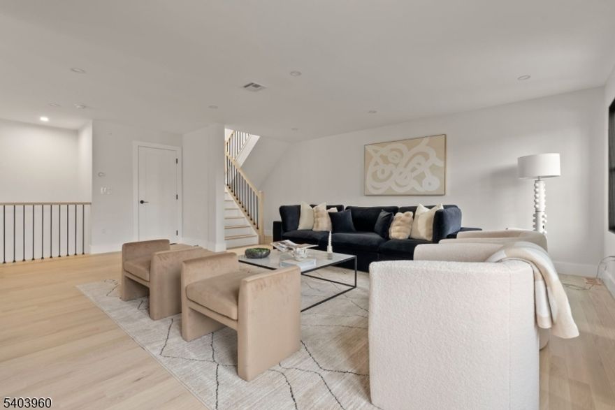 Unit A is a distinguished 3,850 SF new construction residence offering a thoughtfully designed open-concept layout that seamlessly connects the kitchen, dining, and living areas. The main level features a dramatic split level design, with the kitchen and dining area showcasing 13ft ceilings, while the living room sits just above, creating both visual interest and a natural flow. The chef's kitchen is appointed with Fisher & Paykel appliances, custom cabinetry, and built-up countertops that blend functionality with modern design. Oversized windows flood the interiors with natural light and frame views of the private porch and front yard. An attached garage enhances the practicality of this level. Upstairs, two well-proportioned bedrooms share a bathroom, while the primary suite provides a luxurious retreat complete with two walk-in closets and a spa-inspired  bath featuring a massive shower with a built-in bench and rain shower, as well as a deep soaking tub. A second washer and dryer are conveniently located on this floor. The top level adds flexibility with a dedicated office and an additional bedroom with a full bathroom. The finished basement offers a generous secondary living space, including a bedroom with an en-suite bathroom, a spacious laundry room. Only few minutes walk to Bloomfield Ave, where you can enjoy shops, restaurants, cafes, and only 2 blocks from the small Whole Foods. Walking distance to the nearby Walnut St train Station.