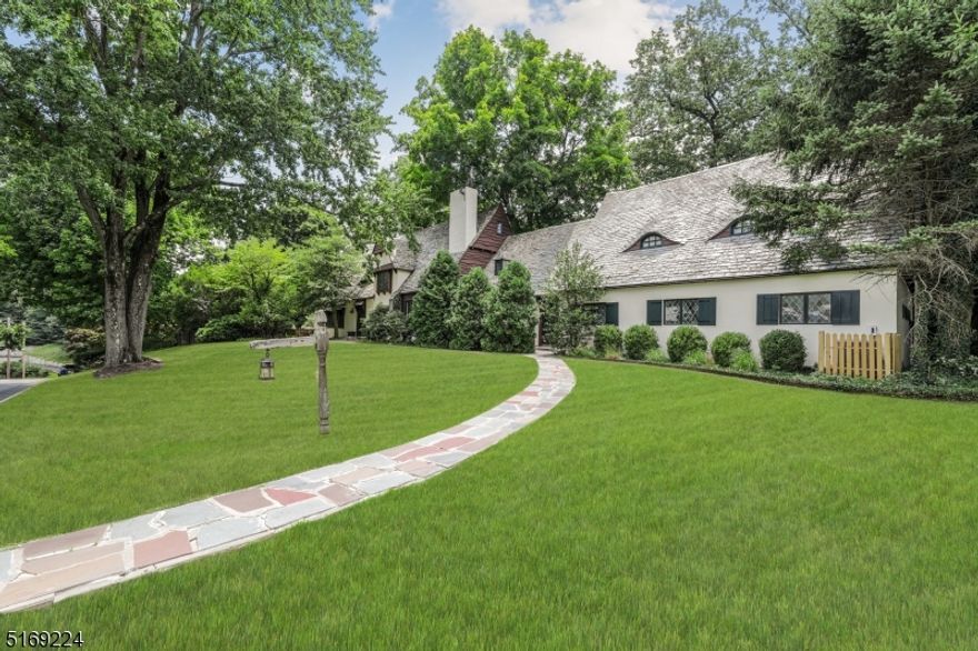 Beautifully constructed 1920's Normandy cottage located in Summit's Northside.  The style dates back to medieval European architecture and the home is built from materials ripe with history.  You will enter the home through a gorgeously constructed solid Dutch door and be struck by the open foyer and unique wood trimmed doorways.  Hand sewn beams and pegged oak wood floors run throughout the expansive Living and Dining Rooms.  The Kitchen, at the center of the house, is adorned with SS appliances, including a 6 burner Viking stove, granite countertops, and attached breakfast nook.  A full bath, Family Room and Mudroom complete the first floor and can be accessed through the 3-car attached garage or by a second front door providing a great option for multi-generational living.  The second floor contains 5 bedrooms and 3 bathrooms with 2 bedrooms being optimal for primary/guest suite spaces.  This floor provides options for a flexible floor plan for the needs of today's buyers with options for additional living or office space.  The third floor provides two more bedrooms and a full bath.  Easy access to the Summit train station, downtown shops, and restaurants.  Buyers looking for a unique home full of charm and European ambiance, this is the house for you!