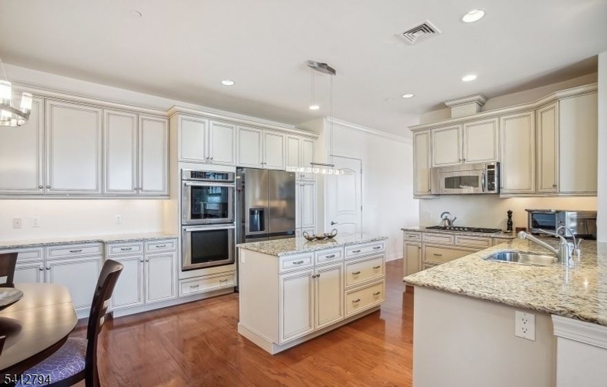 Experience the pinnacle of luxury living in Vizcaya, a premier, gated residential community for a sophisticated worry-free lifestyle. This community offers a modern, resort-style convenience living, including a state-of-the-art fitness center, spa, card room, tennis courts, walking paths, both indoor & outdoor pools, 24-hour guarded gatehouse & security, a dedicated concierge, valet parking services and 2 underground parking spaces. This RARE second floor 3 bedrooms and 3 full baths home boasts a thoughtful, open-concept floor plan designed for both grand entertaining & comfortable daily living.The heart of the home features a spectacular great room where the living/dining areas flow seamlessly together, highlighted by a stunning 2-sided gas fireplace & floor-to-ceiling windows that flood the space with natural light & frame breathtaking views. For more casual gatherings, the family room opens effortlessly to a chef's-inspired kitchen. This culinary hub is equipped with a large center island, wood cabinets, stainless steel appliances, granite counters, double oven & bright, separate eating area. Retreat to the primary bedroom suite, a true private oasis featuring dual walk-in closets and spa-like bath complete with a soaking tub and separate stall shower. Dedicated laundry room, gleaming hardwood floors & dramatic high ceilings throughout. Just minutes away from South Mountain Reservation, premier dining and upscale shopping, and NYC commute via West Orange jitney service.