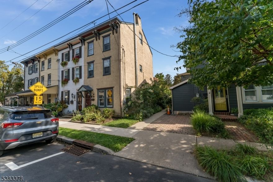 Thoughtfully restored historical home is conveniently located in the heart of Lambertville just one block from Bridge Street, merely steps from exceptional dining and shopping experiences Lambertville has to offer. Upon entering the home, you are greeted by an elegant LR featuring a cozy fireplace which seamlessly connects to the formal dining area. Gourmet center-island kitchen serves as a focal point of the home complete with breakfast bar, quartz countertops, tumble marble backsplash and SS appliances. The modern kitchen is further enhanced by recessed lighting, complemented by stylish pendant fixtures. Ascending to the 2nd floor you'll find 2 well-appointed bedrooms that share an updated bath. The primary master bedroom, located on the 3rd floor boasts a luxurious ensuite bath equipped with dual vanity and frameless walk-in shower featuring a rainfall showerhead. Adjacent to the master suite, the dressing room/walk-in closet offers built-in drawers for added convenience, accented by barn-style sliding doors. A secluded sitting room loft above the BR provides an ideal retreat, showcasing captivating views of the town. This charming piece of history is highlighted by exposed beams, wood floors throughout, decorative beamed ceilings and crown moldings, all of which contribute to its architectural allure. For outdoor living enjoy a private, fenced brick patio and pergola easily accessible through French doors from the kitchen perfect for both relaxation and entertaining.