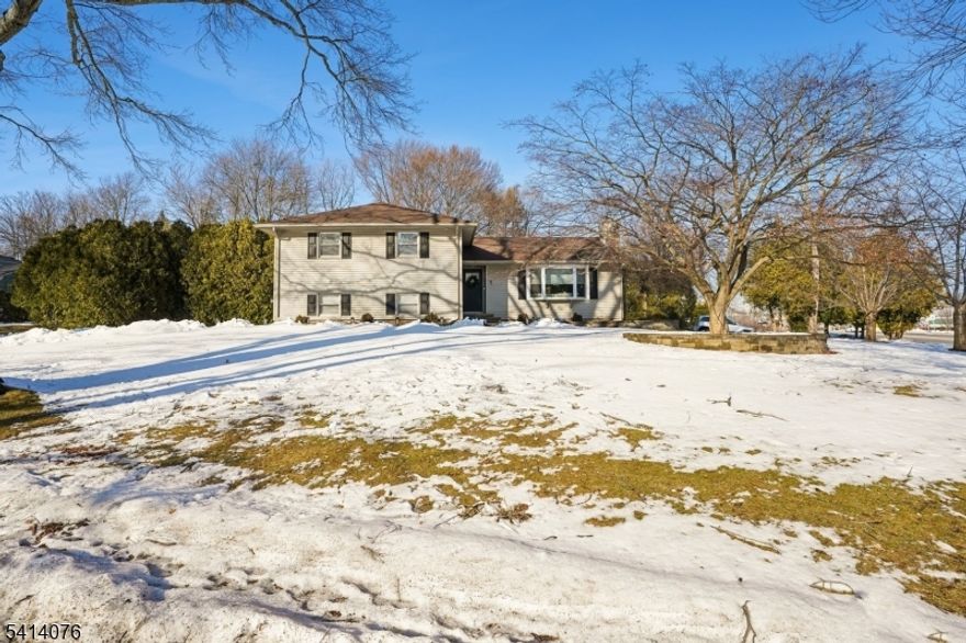 Welcome home! Step through the front door into a bright and inviting 1st floor living room, where the entire interior has been freshly painted & enhanced with recessed high hats throughout, creating a bright, modern feel. The updated kitchen features stainless steel appliances, new countertops, & backsplash, flowing seamlessly into the dining room with built-in custom cabinetry. From the dining area, sliding doors lead to a maintenance-free deck overlooking the patio & flat, open, fenced backyard. Upstairs, the second level offers comfortable bedrooms & full bath accommodations, including a spacious master suite with its own private ensuite bathroom! A hidden bookshelf entrance on this level provides access to additional attic storage, adding both charm & functionality. Head down to the ground level where the current "Bar Room  offers flexible living space with potential to create a 4th bedroom, along with a full laundry room & convenient half bath. Continue to the basement level featuring a spacious Rec Room & two storage areas. The furnace was replaced in 2022, offering added efficiency & peace of mind! Located just minutes from Morris Plains' quaint downtown area & the exciting new Crossings at 10 redevelopment, a walkable town-square style destination with retail, dining, office space, & outdoor gathering areas expected by end of 2026. You're also minutes from the Morris Plains Train Station with NJ Transit Mid-Town Direct service to NYC, & the NYC Park & Ride!