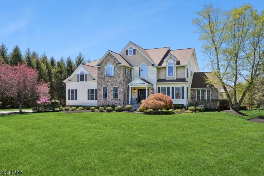 Set on almost 3 acres of manicured grounds in the premier Landmark at Long Valley, this stone-accented Colonial is the embodiment of sophisticated country living. Combining 4,436 sq ft of architectural grace w/high caliber amenities of a private resort, this remarkable property, w/finish low entertainment level & 3-car garage, offers a rare lifestyle where traditional elegance meets modern functionality. From the custom mahogany entrance & 2-story foyer w/dramatic turned staircase to the sun-splashed conservatory, every inch of this 4 bedroom, 3 full & 2 half-bath residence is defined by exquisite millwork & oak hardwood flooring. At the heart of the home, an epicurean center island kitchen featuring Conestoga cherry cabinetry & professional-grade Viking & Fisher & Paykel appliances, flows into a two story great room anchored by a floor to ceiling stone fireplace. The primary sanctuary is equally impressive, offering fireside sitting room & a spa-inspired bath w/jetted tub. While the interiors provide a masterclass in craftsmanship, the exterior is a dedicated entertainment destination. A heated Grecian gunite pool with cascading waterfall & spa is complemented by a designer pool house with a granite bar, a towering gazebo with its own stone fireplace, and expansive Techo-Bloc terraces. Located in the scenic heart of Morris County, this property represents the pinnacle of luxury in a community celebrated for its rural charm and top-tier International Baccalaureate education.