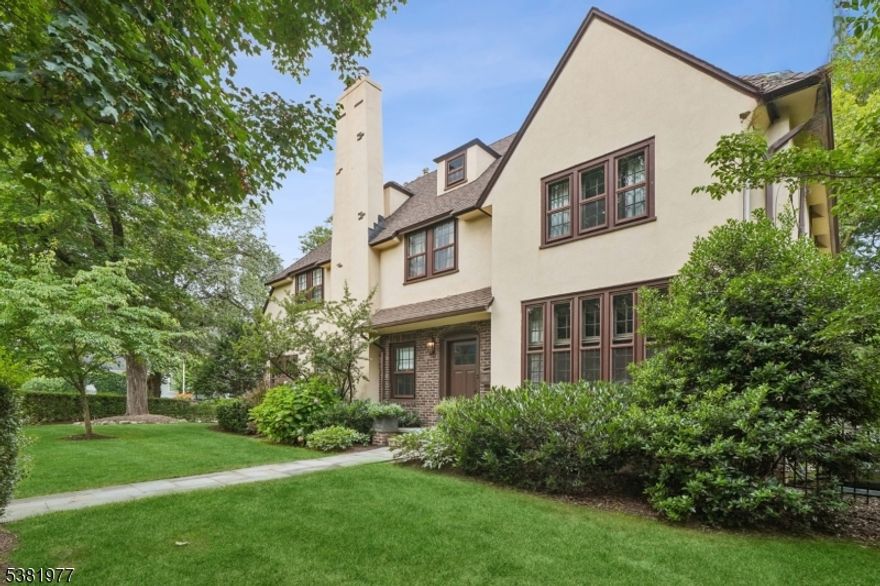 IDEAL SUMMIT LOCATION * FABULOUS 1923 ENGLISH TUDOR * Set on exceptionally private property in one of Summit's most desirable neighborhoods, yet just three short blocks to Summit's vibrant downtown, this home blends timeless character with modern luxury. Inside, beautiful architectural details-beamed ceilings, custom woodwork & elegant windows--are paired w/ today's most sought-after renovations. Gracious foyer opens to sun-filled LR with wood-burning fireplace, conversation nook, plus a family room/home office w/ custom lighting & windows on three sides. Banquet-sized dining room flows into the show-stopping gourmet kitchen. Here, custom-designed Euroline steel windows, Caesarstone counters w/ bar seating, butler's pantry w/ coffee bar, custom cabinetry, SS appliances (Wolf/Bosch) lead to mudroom w/ heated ceramic floors, back entrance,1st floor laundry, powder rm & att 2-car garage. Sonos-ready speakers, wine cellar, security system, Tesla charger. Upstairs, 5 BRs & 3 FBs include fab primary suite w/ walk-in closet & spa-like bath & private 3rd flr suite. Finished LL: rec rm, office, workout space & full bath w/ steam shower. Outside, detached backyard annex offers unlimited possibilities: playroom, gym, artist's studio or future pool house. Backyard is an entertainer's paradise, featuring paver patio surrounded by perennial gardens & level lawns (room for pool). All this & Summit's top-rated schools (Brayton), Summit Art Center & easy access to NYC (0.5 mi). Welcome Home!