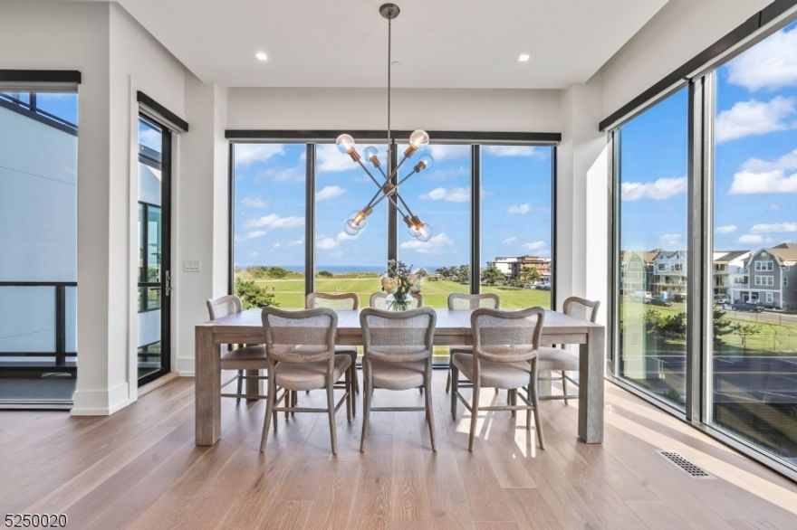 Expansive coastal townhome - the epitome of shore living. Located just a block from the beach, this direct east-facing four level 3,100 sqft townhome offers breathtaking views of the ocean. This home encompasses 5 bedrooms, 5 full bathrooms and comes fully-furnished with designer indoor and outdoor furniture. Residence features a private elevator, whisking you effortlessly to every floor.The highlight of this coastal haven is the spectacular private rooftop deck, complete with Lynx gas grill and fire pit. Indoors, you'll find an array of premium upgrades, including open glass railing staircase with Artic White Stone accent wall, as well as Walnut TV Feature Wall. Chef's kitchen equipped with Sub-Zero and Wolf appliances, Caesarstone Frosty Carrina quartz countertops, and Ultra Craft Artic White Cabinetry. Spacious attached two-car garage with a Clopay Avante frosted glass door & electric car charging station. Additional upgrades include closet systems with cabinetry components, rooftop cabinetry and refrigerator, whole-house generator, electric ignition for rooftop fire pit, epoxy-coated treatment garage floor. This coastal retreat is part of a vibrant community with outstanding amenities, including two pools, fitness facility, community center, and nature trails. Close proximity to the beach, Pier Village, exquisite dining options, country clubs and entertainment venues. Few miles from Seastreak Ferry offering high-speed journey to NYC in under an hour.