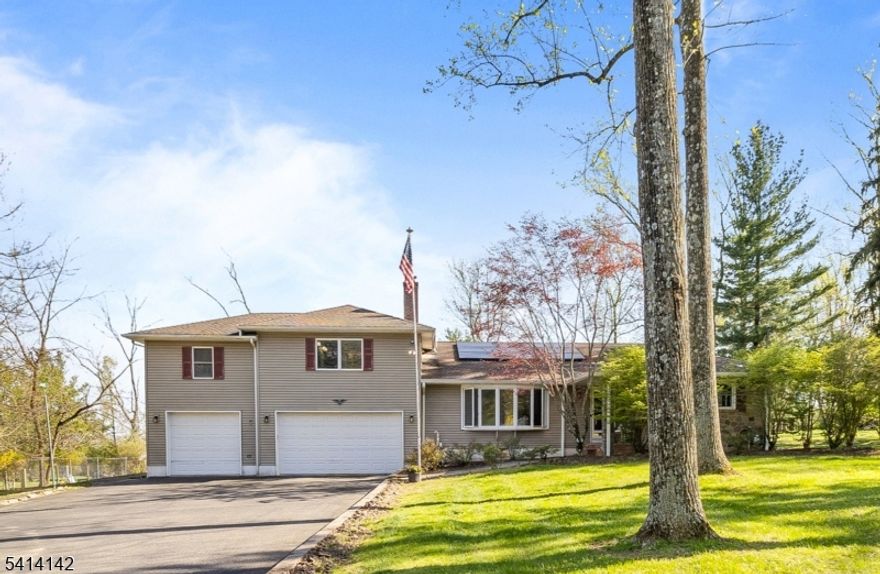 **Highest & Best due by Wednesday 4/22/26 @ noon** Expansive & versatile custom home beaming with character & charm.  Natural sunlight brightens the living room through large bay window showcasing the stone fireplace.  The dark cherry cabinets & window seat in kitchen invite a nostalgic warmth. Primary bedroom suite has such a modern feel offering a wall of windows, balcony, walk in closet & 2 oversized storage closets big enough for a home office or nursery.  Additionally, a gas-fired, direct vent fireplace and primary bathroom with oversized walk-in shower & steam feature adds a touch of luxury. Septic upgraded (2017), Roof (2019), 6" gutters (2022), 10KW Solar system/owned (2023) credits transferrable to next owner, New AC (2023) gas boiler & 40-gallon hot water holding tank less than 10 yrs old.  Laundry upstairs, along with 2.5B & 2 or 3BR depending on how utilized.  Lower-level family room & 2 possible bedrooms & full bath with access to outdoor & garage.  Full basement for storage, currently used as workout room.  Patio, 3 car garage, oversized driveway and easy access to highways, shopping & desirable HCRHS school district. Close to parks, farm stands & up & coming downtown Flemington
