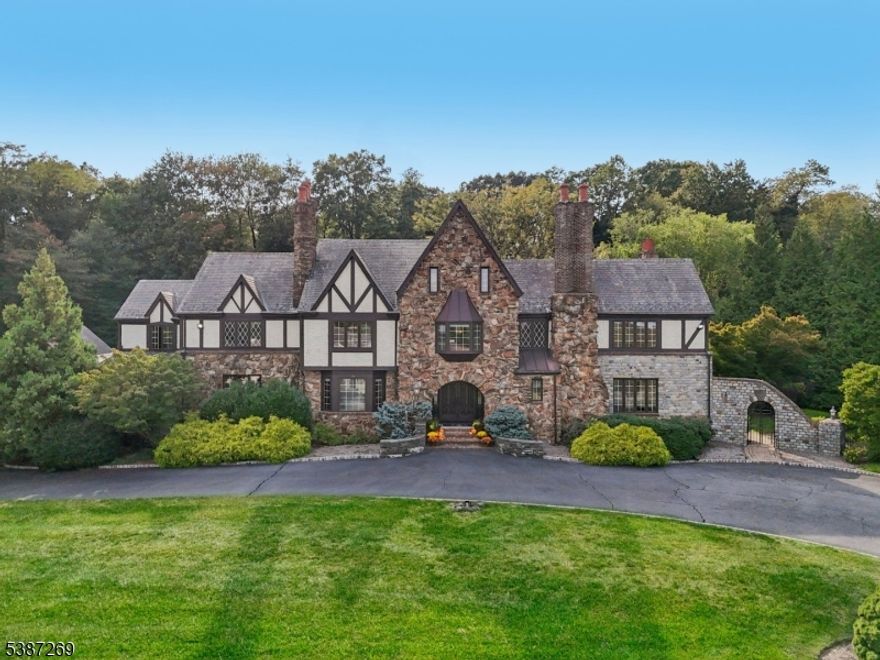 This exceptional 5-bedroom, 5.1-bath estate is a rare find, blending architectural interest with inspired design and functionality. Nestled on a quiet cul-de-sac in one of Scotch Plains' most desirable neighborhoods, it sits on 1.34 park-like acres with amenities for entertaining and everyday living. A striking stone exterior opens to expansive rooms, hardwood floors, five fireplaces, and a dramatic two-story living room with a spiral staircase to a wrap-around library. The chef's kitchen, renovated in 2019, features a 60" Lacanche range imported from France, dual Sub-Zero refrigerators, two dishwashers, and custom cherry cabinetry. The luxurious primary suite offers dual walk-in dressing closets, a spacious sitting area retreat with fireplace, and a private spiral staircase to a loft, creating a true spa-like escape. Multiple formal and informal living spaces make gathering easy. The third floor and finished lower level provide additional retreats, including two bedrooms, a full kitchen, wet bar, full bathroom, entertainment areas, game rooms, exercise room, and separate garage entrance. Outdoors, enjoy a heated in-ground pool and spa, three patios, a gazebo with lighting and integrated sound system, professional landscaping, and privacy on all sides. Two garages accommodate five cars, with the detached garage offering a workshop and additional storage.