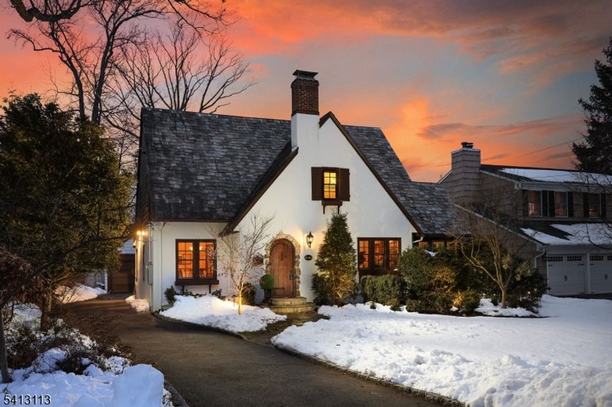 This storybook Tudor-style home blends timeless charm with modern comfort, offering exceptional curb appeal and move-in-ready convenience. Gleaming hardwood floors & abundant natural light create a warm, inviting atmosphere throughout. The welcoming entry foyer opens to a gracious living room featuring a wood-burning fireplace, perfect for cozy evenings at home. A spacious formal dining room provides an elegant setting for gatherings and seamlessly connects to the expanded eat-in kitchen. The kitchen is thoughtfully appointed with a center island breakfast bar w/sink, granite countertops, new dishwasher, stove & microwave, plus a sunny breakfast area with French doors leading to the backyard. A sunroom provides a peaceful retreat while the family room adds generous space for comfortable everyday living. Upstairs, the primary suite features a private bath with natural stone tile and a stall shower. Two additional generously sized bedrooms and a full hall bath complete the second floor. The partially finished basement incl a playroom and laundry area, offering flexible bonus space. Outdoor highlights incl beautifully landscaped grounds, patio for entertaining, stone-edged driveway & 2-car det garage. Recent 2025 upgrades incl new central air conditioning & hot water heater. Ideally situated in a picturesque neighborhood near schools, parks, downtown shopping and dining, and convenient NYC transportation, this special home offers comfort, character, and convenience all in one.