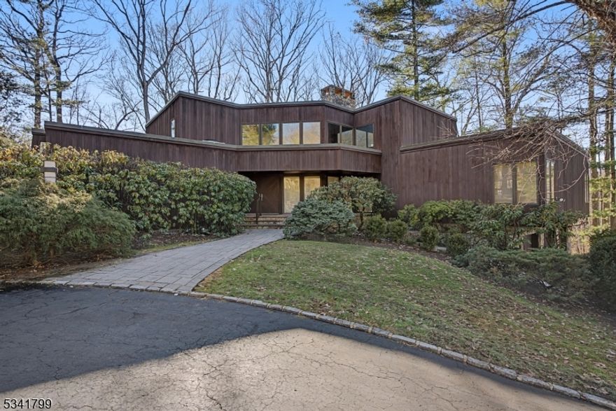 Distinctive 3BR, 3.1 BA mid-century modern gem is set on 1.5 acres of private wooded landscape in desirable neighborhood in Watchung offers 3,748 sq ft of comfortable, stylish living & gracious entertaining space! Beautiful curb appeal w/ redwood siding, circular driveway, paver walkway, stone front porch & double doors. The foyer entry revels the dramatic Great room w/ soaring ceilings, walls of windows & spectacular 20' floor-to-ceiling Georgian marble stone fireplace! Open design flows to elegant dining room and multiple sliders leading to a large wood deck overlooking the natural setting. Convenient 1st floor primary ensuite offers peaceful views, updated full bath, custom built-in furniture & closet w/ skylight. A second 1st floor ensuite w/ its own bath provides flexibility and can also serve as a home office. Bright kitchen features Poggenpohl cabinetry, skylight, Sub-Zero refrigerator, pull-out pantry units, angled windows and slider to deck, is ready for your personal touch. Large laundry room with skylight, large closet & service entrance, beautiful powder room w/ skylight & double coat closets add comfort and convenience. Upstairs, a 3rd bedroom, full bath & inviting family room w/ fireplace & handcrafted birdseye maple paneling & bookcases add warmth and character. LL includes  3-car garage, wine celler, walk in cedar closet & 2 large unfinished spaces. Ideally located, minutes to highways, NJ Transit trains and buses, Watchung lake and area hospitals.