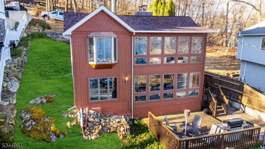 Wake up to INCREDIBLE LAKE VIEWS of highly sought-after Lake Hopatcong from virtually every single room featuring OVERSIZED Windows all throughout. Located on New Jersey's largest lake, this property includes deeded Dock rights for easy access to Boating, Jet Skiing, Water Sports, 3 Sand Beaches, a Fishing pier & Clubhouse. Interior highlights include hardwood floors throughout, a working fireplace, travertine tile in the bathroom, a BONUS ROOM ideal for an Office/Den, Bosch Dishwasher, inductive Range, Pot Filler, and heated Towel Rack. Upgrades include a new Roof (2024), new Central A/C (2025), Tankless hot water heater, Roth Oil Tank, Roth Septic Tank, and generator hookup with transfer switch. Close to waterfront restaurants, bars, entertainment. Enjoy lake living at its finest!