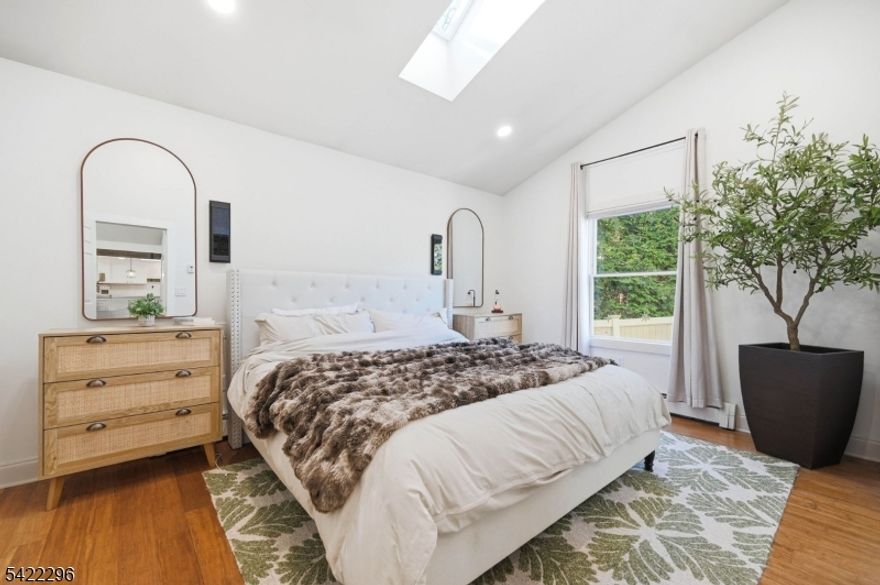 Step into a lifestyle defined by light, ease, and understated sophistication. A welcoming front porch opens to a sun-drenched interior with soaring ceilings and sleek floors, creating an airy, effortless flow for maximum relaxation or entertaining. At the heart of the home, the bright kitchen features an oversized eat-at peninsula, ample cabinetry, sleek countertops, and a skylight. The open dining area invites cozy nights in, while the primary suite offers a private bath and generous closet space. A second bedroom is filled with natural light. The oversized garage goes beyond parking, offering a workshop and a versatile loft space to fit your needs. Outside, a private fenced backyard feels like your own retreat, complete with a patio, lush lawn, garden space, and a shed. Located just moments from Hopatcong State Park, where you can enjoy the water, trails, and natural beauty year-round. Choice between Lenape or Hopatcong School Districts.