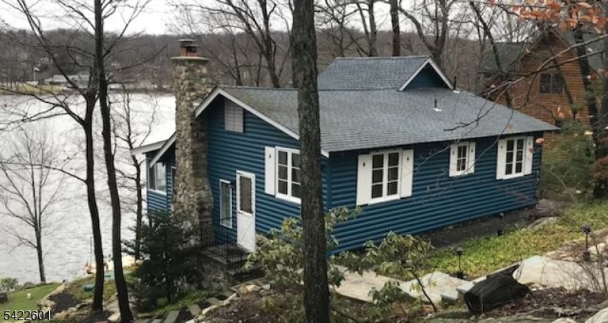 Enjoy exceptional main-lake lakefront living with deep water and gorgeous sunsets from your private dock and inviting enclosed sunroom. Perched high on the lot for sweeping lake views, this special setting offers a true front-row seat to lake life. Ideally located across from the main beach and clubhouse, where you can enjoy swimming, gatherings, and a variety of seasonal activities bringing the energy and charm of the lake right to your doorstep.Welcome Home
