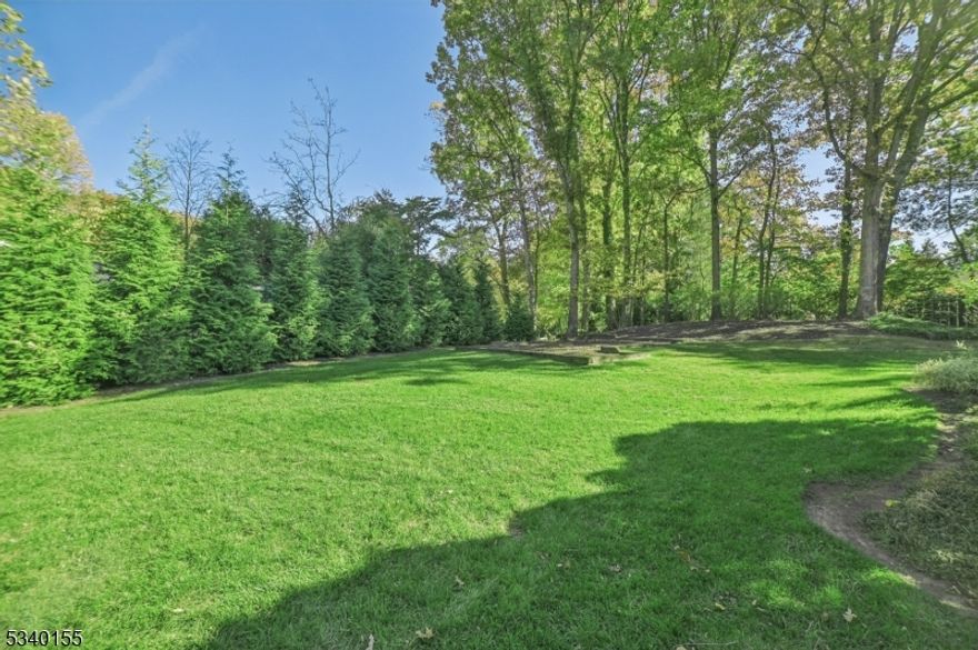 This exquisite Center Hall Colonial home with 5 bedrooms and 4.5 bathrooms situated on 2/3 acres seamlessly blends classic charm with modern luxury. A grand circular driveway makes a striking first impression, leading to a home that exudes timeless elegance with an inviting flow and abundant natural light. Inside, discover impressive millwork, oversized windows, and intricate detailing that elevate every space. The foyer welcomes you into the formal Living Room seamlessly flowing into an expansive Great Room -both with French doors to the expansive deck and private yard. The Great Room leads to a Sunroom with soaring cathedral ceilings. The formal Dining Room leads to the gourmet Eat-In chef Kitchen with custom cabinetry, top-tier Viking appliances, a center island with granite countertops + breakfast area. The adjoining family room and a Powder Room complete the 1st level. The 2nd level features an opulent Primary Suite with a private office/sitting room overlooking the Sunroom, dual walk-in closets, and a spa-like bath. The 4 remaining upstairs bedrooms share 2 Jack & Jill full bathrooms.  The finished lower level provides a media room, recreation space, full bath, and ample storage + direct access to the attached 2-car garage. Beyond the home's extraordinary features, enjoy access to the top rated Millburn School District, shopping, and direct NYC train access - offering the perfect blend of suburban tranquility and metropolitan convenience. Approx sqft includes LL+Garage.