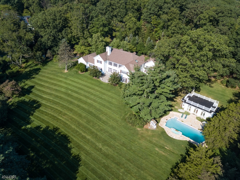 "White Oak Manor", a private, gated driveway guides you to this 12 room country estate on 22.29 acres in the Far Hills section of magnificent Mendham Twp-5 bedrooms including a first floor guest suite , 4 full and 2 half baths, 2 fireplaces, high ceilings, dramatic double staircase and great room with floor to ceiling windows with stunning views,magnificent master with sitting room and his and her closets, aupair apartment w full bath, and two large bedrooms with Jack & Jill bath. Sparkling in-ground, heated pool & spa along with newly renovated pool house complete with heat/cooling,bath, full bar, kitchenette and roof top deck all combined to create a true outdoor paradise-perfect for entertaining or daily repose. 4 car garage, mesmerizing sunset views. Country estate living at its finest!