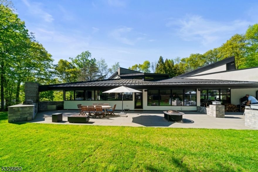 Seeking the ultimate in secluded privacy only minutes from Manhattan? Discover this elegant contemporary home located at the end of a cul-de-sac in one of Cresskill, NJ's most desirable neighborhoods. Set on over two meticulously landscaped and forested acres in the most private of settings, this recently renovated home features soaring ceilings and expansive windows that seamlessly blend indoor and outdoor living spaces. Enjoy the immense bluestone entertainment area with outdoor kitchen, or unwind in the heated in-ground pool nestled in a secluded blue stone courtyard. Relax with a glass of wine from your temperature-controlled wine cellar, watch a movie in your high-end home theater or relax and enjoy your favorite music through the built-in Nain/B&O audio system. Then retire to the primary suite with its lofty cedar ceilings and white oak floors, and enjoy the peace of your spa-like primary bath. VIRTUAL TOUR gives access to property website for additional information.
