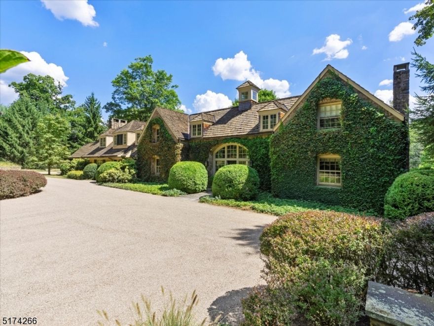 This sophisticated c1885 English Country Cottage style residence, privately sited on approximately five acres, has been carefully updated over the years with careful attention paid to retaining the antique integrity while modernizing for today's expectations. The home offers generously sized rooms, hand hewn beams, wide plank wood floors, intriguing architectural details and abundant natural light throughout. Designed for a serious cook, the updated Kitchen has expansive custom countertops and cabinetry while featuring Viking, SubZero, Bosch and other high end appliances.  Opening to the Family Room and window walled Dining Area, the Kitchen also has a separate Butlers Pantry that connects to the formal Dining Room. The front to back Living Room has an Amish 'chip carved' mantel while a cozy Library could serve as a first floor office. The Primary Bedroom includes a Sitting Area, multiple walk-in closets and an updated bath with soaking tub. Four additional Bedrooms and two baths complete the second level. The house has a one car garage and a detached two car garage with a well designed office above - perfect for working from home. The Pottery is a charming stone building currently used as an artist's studio. The grounds offer bluestone terraces, a wisteria covered pergola, a kitchen herb garden, fieldstone walls, and a heated pool.  Convenient to fine dining, shopping, parks, equestrian facilities, golf courses, NJ Transit train and major highways.