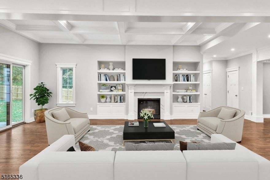 This magnificent new construction with 5,000 square feet of living space is reminiscent of a modern farmhouse with a travertine and stone exterior. Inside, the stunning two-story foyer opens to luxurious living spaces with 4' red oak flooring and high quality finishes throughout. The gourmet kitchen boasts GE Monogram stainless-steel appliances, quartz countertops, custom white cabinetry extending to the ceiling, farmhouse sink, enormous island and 2 pantries. Dining room is open to the kitchen with a coffered ceiling and beautifully crafted millwork. The family room also boasts a coffered ceiling and has sliders to the rear patio and a gas fireplace flanked by built-in cabinetry. Completing the first level is the formal living room, ensuite bedroom, powder room, and mudroom with built-ins. Upstairs has an enormous media room, 4 bedrooms (2 en-suite, 1 Jack & Jill bath) and laundry room. All baths have quartz countertops and porcelain tile floors. The primary suite has a balcony overlooking the pool, 2 huge walk-in closets and bathroom with soaking tub and spa shower. The finished lower level offers 2,200 square feet of additional living space with a legal bedroom and full bath. Outside features a covered patio with stone fireplace, speakers, bluestone pavers and cedar ceiling. Steps away is the fiberglass pool surrounded by custom stone work, professional landscaping and lighting. Located in a top NJ school district close to shopping, parks, restaurants, and transportation.