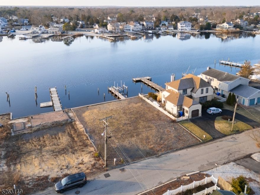 Waterfront lot with serene views and access to Barnegat Bay by boat is now available! Build your custom dream home in the lovely Bay Harbor community in Brick Twp. This level lot has been cleared and includes a 40 ft dock, 12 x 4 floating dock, 7000lb electric boat lift, 75 ft of bulkhead, riparian grant, riparian lease dock permit, and connections available for water, natural gas, electric, and cable. The building envelope previously suited a 2500 sq ft home. The Bay Harbor Beach Park is nearby with beach, bulkhead for crabbing, play yard, and a kayak drop. This is a great location near groceries, shopping, restaurants, shore beaches, and driving and water routes. Proof of funds are required, and buyer is responsible for due diligence.
