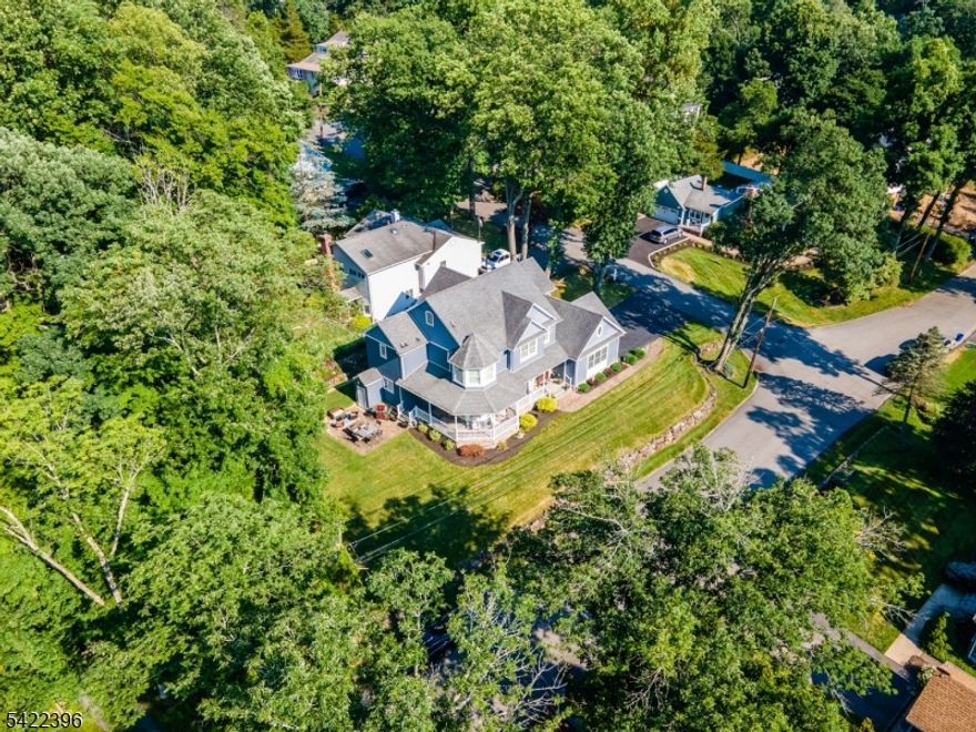 Welcome Home to this one of a kind spectacular custom colonial in desirable Packanack Lake. This meticulously maintained 4 bedroom/2.5 bathroom home boasts an open floor plan with soaring ceilings, hardwood flooring/tile and custom molding throughout. The large wrap around front porch with ceiling fans welcomes you as you enter this stunning home. The center island kitchen w/granite countertops, stainless steel appliances & double wall ovens also includes your very own butler's pantry equipped with both a kegerator and beverage fridge. The great room is the heart of the home which includes a floor to ceiling exposed stone gas fireplace and oversized windows. The first floor also features a formal dining room, living room, laundry room, powder room, and den/office which can also be used as the 5th bedroom.  The second floor hall overlooking the great room features 4 bedrooms including the primary suite which has its own sitting area, large walk in closet and bathroom with glass enclosed shower, double sinks and extra large tub. The 3rd floor is the walk up attic with full ceilings prepped and ready for finishing. The full basement has extra high ceilings, an entrance to yard and is also prepped and ready for finishing. Other special features of this home include: recessed lighting, plantation shutters, sprinkler system, home alarm system, built in dehumidifier, home water filter, and blue light HVAC..