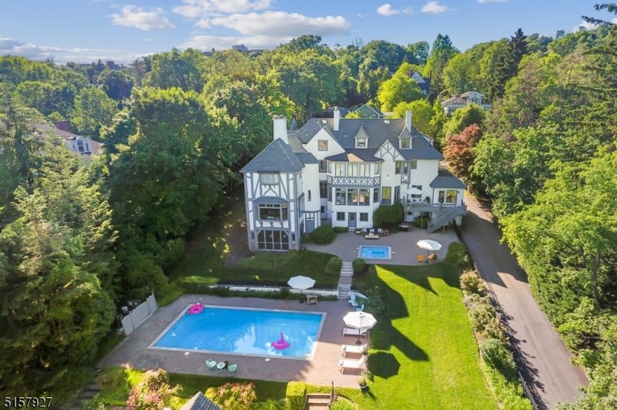 Recently reimagined with a huge dose of hip, this beloved English Manor with NYC views boasts a perfect balance of updates for comfortable livability with gracious architectural integrity. Quiet, friendly street is just blocks from our vibrant downtown  - or maybe you'll want to stay poolside in your private back yard with screened porch. Inside, original bespoke details with a fresh palette. Stunning first floor wet bar with marble counters & custom cabinetry, hand painted Living Room wallpaper, updated eat-in Kitchen, crisp decorative touches complement original coffered ceilings & oak paneling. Inviting Main Entry leads to an enveloping Family/Media Room you'll swoon over. Gorgeous Dining Room & inspirational, private 1st floor Office with adjacent library nooks for total wow!  - all reflect high quality stewardship & improvements by the current owners. Upstairs, stunning sunrise & city views from Primary Ensuite with large dressing room & spacious Bath with soaking tub & stall shower. Choices of lovely, refined, bright spaces for play, sleep, work & entertaining. 3-car garage. Just under an acre of property. It's time to live well & enjoy!