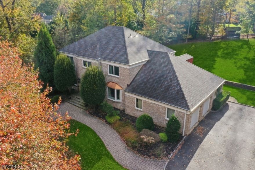 STATELY ELEGANCE * EXPANSIVE PROPERTY * Welcome to this stunning, modern brick Colonial, perfectly set atop 0.64 acres in one of Short Hills' most desirable neighborhoods. From the moment you enter the custom-designed foyer with its sweeping staircase, you'll sense the elegance and craftsmanship that defines this exceptional home. Entrance flows effortlessly into banquet-sized dining rm & formal living rm each w/ large windows. At the heart of the home is a gourmet kitchen, featuring Corian countertops, center island w/ seating, double ovens, and bright breakfast area, ideal for both everyday meals & entertaining. Off the kitchen is a bar area, cozy fireside family rm w/ a gas fireplace, and versatile sunroom/home office w/ beautiful backyard views. 1st flr ensuite BR provides excellent flexibility, along w/ powder rm & convenient laundry/mudroom.Upstairs, the luxurious primary suite is a private sanctuary w/ dual custom-fitted WICs and a spa-inspired bath featuring radiant heated flrs, double vanity, glass shower & soaking tub. Five additional spacious BR & two beautifully renovated full baths complete the 2nd flr. LL: exceptional living space, including kitchenette, rec room, exercise space & half bath. MORE: built-in generator, sprinkler systm, landscape lighting, Low Taxes! Peaceful & private, yet minutes to top-rated Millburn schools (Deerfield Element), niche boutiques & trains to NYC. The perfect harmony of refined luxury & everyday comfort.