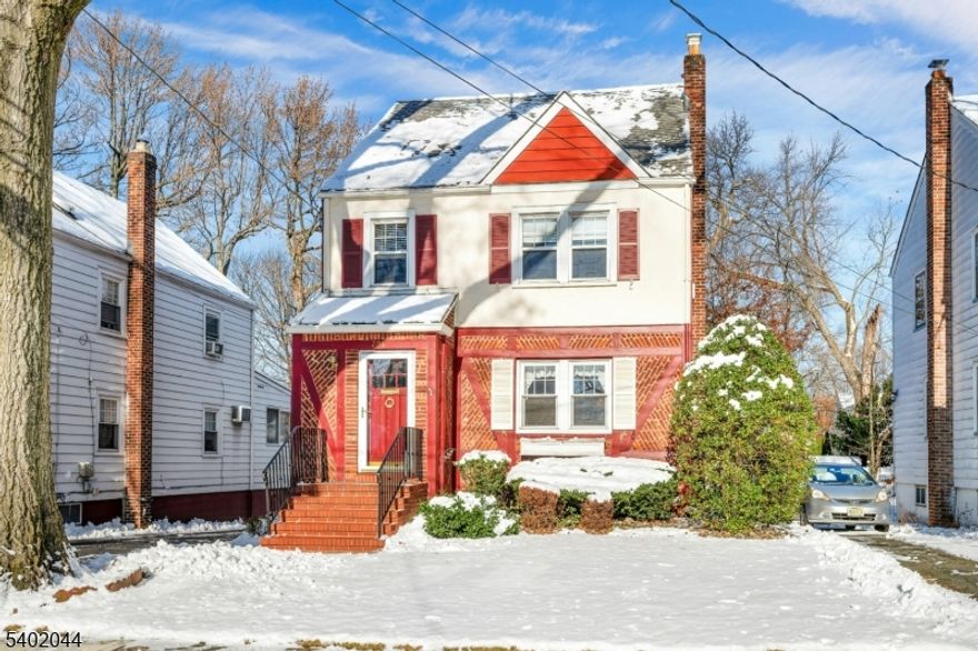 This storybook Oakview Colonial blends timeless character with everyday comfort. A stucco and brick facade with rich reddish trim sets a welcoming tone. Step inside to a spacious living room that flows gracefully through an arched doorway into the formal dining room, adorned with crown molding and gleaming hardwood floors. The eat-in kitchen features classic wood cabinetry and room for casual dining. A bonus first-floor den and convenient powder room add versatility to the layout perfect for a home office or cozy retreat. Upstairs, you'll find two comfortable bedrooms plus a tandem room ideal as a nursery, office, or creative space leading to a finished, heated attic that can serve as a playroom, studio, bedroom or guest area. A full bath completes the second floor. Enjoy outdoor relaxation in the private rear yard. This well-insulated home features updated windows, gas steam heat, and charming stucco walls that lend warmth and character throughout. Located just steps from the NYC bus, supermarket, houses of worship, and the award-winning Oakview grammar school. This delightful home offers convenience, comfort, and classic appeal. Truly a pleasure to show!