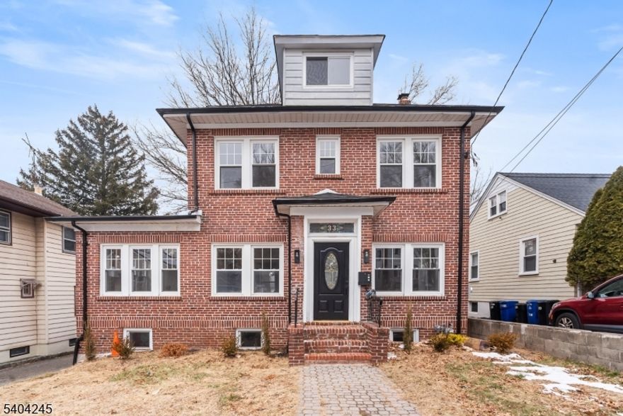 Welcome to 33 Robertson Road, an elegant all-brick Colonial located in the highly desirable town of West Orange. Thoughtfully updated while preserving its timeless charm, this residence offers refined finishes, generous living spaces, and a brand-new roof. A sun-filled living room sets the tone and flows seamlessly into the open-concept kitchen and dining area, ideal for both everyday living and entertaining. The chef's kitchen is appointed with quartz countertops, stainless steel appliances, custom cabinetry, and an expansive center island. The main level also features a stylish powder room and a versatile sunroom, perfect as a private home office or serene retreat. The second level presents three well-appointed bedrooms and a beautifully updated full bath with contemporary fixtures. Two additional spacious bedrooms are located on the third floor, offering flexibility for guests, work, or additional living space. The partially finished walk-out basement includes a full bath, laundry area, storage, and flexible space for recreation or relaxation. Outdoors, a private backyard and patio provide an ideal setting for entertaining or quiet enjoyment. A detached two-car garage and extended driveway offer ample parking. Just blocks from NYC transportation and moments from shopping, dining, schools, and major highways, this exceptional home delivers both luxury and convenience.