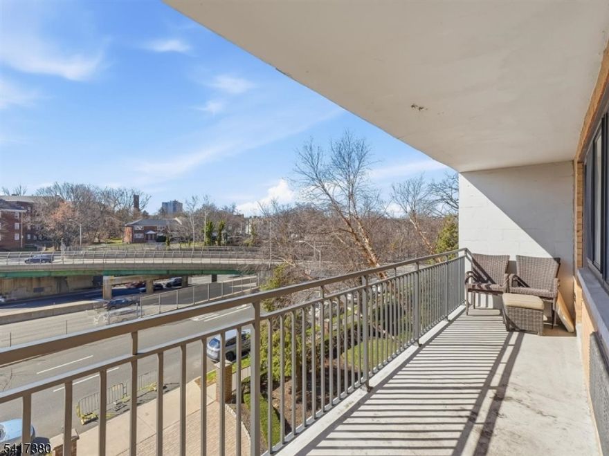 Welcome to this beautifully appointed move-in-ready condo featuring the largest floor plan (1,026 sq ft) in a highly desirable luxury high-rise building. Located on the 4th floor, this bright and airy home is filled with natural light streaming through the impressive 22-foot living room window. The open-concept layout seamlessly connects the living, dining, and kitchen areas. Gleaming hardwood floors add warmth and elegance throughout. The modern kitchen features shaker wood cabinets, granite countertops, a center island with seating for three, and stainless-steel appliances. The spacious primary bedroom offers large picture windows and exceptional storage, including a custom designer organizer in the large walk-in closet plus three additional closets. Step outside onto the expansive 22-foot balcony offering a spacious outdoor retreat with beautiful city views, perfect for relaxing or enjoying morning coffee. Additional amenities include bonus storage space and a designated parking spot. The building offers a resident lounge with TV and pool table, fitness center, laundry room, 24-hour concierge service, full-time superintendent, and outdoor barbecue area with picnic tables. Ideal commuter location with NYC express bus in front, East Orange train station a few blocks away, easy access to the Garden State Parkway, I-280, and only 7 miles from Newark Liberty International Airport. Building not FHA approved. Cash or conventional financing only.