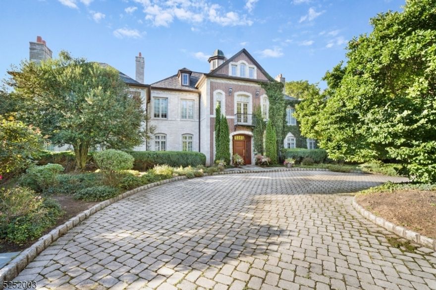 Behind the gated entry, this residence is a masterpiece with custom-made bricks, reminiscent of a European chateau. The grand foyer welcomes you with a circular staircase connecting floors, setting the tone for opulence. The game room features a coffered, hand-painted ceiling inspired by Loire Valley chateaux, and wooden floors add a touch of nautical elegance. Italian marble fireplace mantels adorn living spaces. The gourmet kitchen boasts two islands, granite countertops, and a charming trellis accent. Walls of windows in the dining area provide views of the rear yard oasis. An adjacent office with a custom-made wall unit complements the design. A wet bar butler's pantry connects the kitchen with the formal dining room, highlighted in New Jersey Design magazine. A custom pool table room adds entertainment to the main level. On the second level, a primary suite features a fireplace and French doors to an outdoor balcony. The en-suite bath centers around a columned soaking tub. Four additional en-suite bedrooms offer comfort and privacy. The lower level accommodates privacy with a kitchen, bonus room, bath, and a special wine cellar with meticulous temperature control. The entertainment room includes a fully functional stage. The property's outdoor space provides a picturesque setting with an expansive patio. An outdoor pool and pool house add a touch of luxury, perfect for hosting events. A four-car oversized garage completes this exceptional residence.