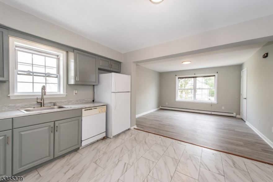 This bright and freshly updated 2nd-floor apartment features a spacious open-concept layout with large windows and stylish flooring throughout. The living room flows into a modern eat-in kitchen equipped with gray shaker cabinets, tile floors, and ample counter space. Enjoy two sun-filled bedrooms with generous closets, and a full bath with contemporary finishes. Additional highlights include neutral paint tones, great natural light, and baseboard heating. Conveniently located near shops, restaurants, and transportation.