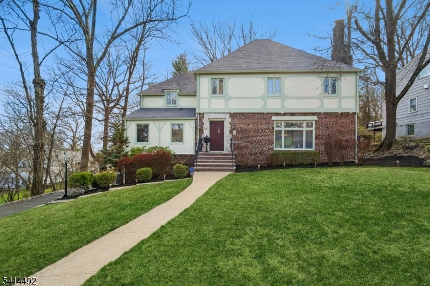 Gracious Tudor-style home in the sought-after Upper Wyoming neighborhood offering 4 bedrooms, 2 full and 2 half baths, and a three-car garage. A circular floor plan with spacious rooms creates an ideal layout for everyday living and entertaining.  The kitchen features stainless steel appliances, a new double oven, and a sun-filled breakfast area, and opens to the family room. New Pella sliding doors lead to a deck overlooking the backyard perfect for indoor-outdoor living. Distant seasonal views of the New York City skyline are visible from the family room, deck, and an upstairs bedroom.The primary suite offers hardwood floors, generous closet space, and an ensuite bath with dual sinks and a soaking tub. Two additional bedrooms and a full bath complete the second level, with a fourth bedroom on the third floor.The fully renovated lower level features a recreation room, brand-new powder room, and direct access to the driveway.Recent updates include two new gas boilers, newly finished lower level, new lower-level windows, double oven, and Pella sliding doors. Conveniently located near South Orange Village and NJ Transit Midtown Direct.